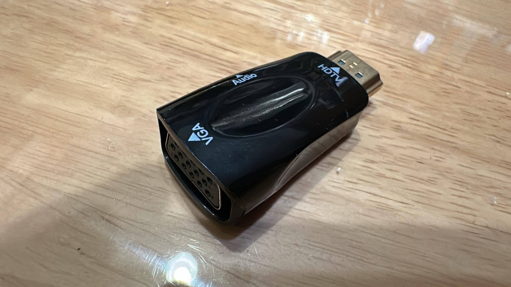 Black adapter with an HDMI plug, VGA socket, and Audio and VGA markings.